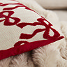 close up on red bow pattern of natural cushion