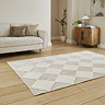 angled image of diamond checkered rug in beige and white in front of cream sofa on wooden flooring