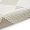 image of white and beige checkered rug rolled up on one end