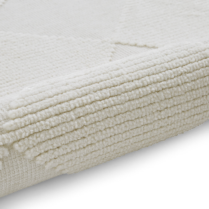 image of cream checkered rug rolled up on one end