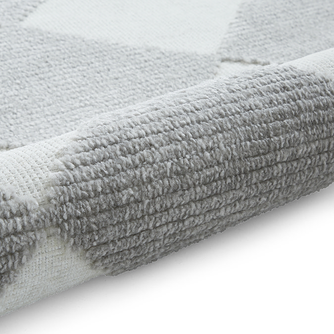 image of grey and cream checkered rug rolled up at the end