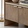 close up image on fluted bottom drawers of mango wood shelving unit with brass handles