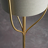 close up image on brushed gold undercarriage of linen floor lamp