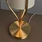 close up on brushed gold base of conical table lamp