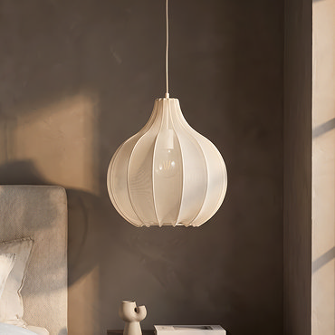 image cut out on white background of sand coloured hanging light with delicate shade, bulb inside emitting warm light