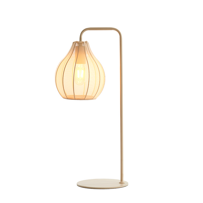 cut out of cream table lamp with sheer flower-inspired shade, warm glow emitting from bulb inside