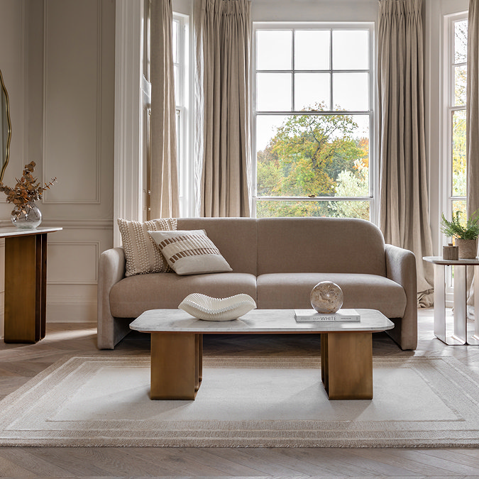 wide shot of marble and gold coffee table on soft rug of living room