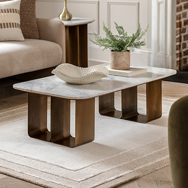 close up on gold geometric base of coffee table with smooth marble top