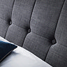 close up on plush button detailing of slate grey fabric headboard
