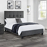 image of slate grey fabric bed with plush high headboard, on dark grey flooring of modern bedroom
