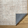 image of brown and tan coloured vintage floral rug folded over at the corner to show material underneath