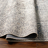 close up image of grey vintage rug folded up slightly to show thinness