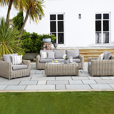 image cut out on white background of rattan 3 seater lounge sofa, with plush grey cushions