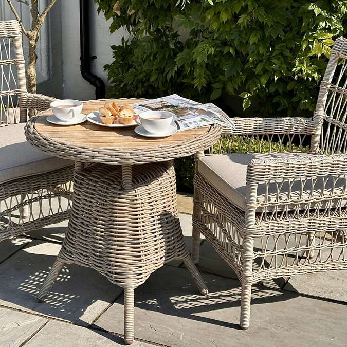 image of bistro table with wicker chair next to it on garden patio