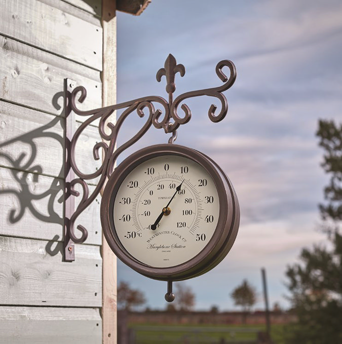image of station wall clock at dusk on side of shed