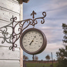image of station wall clock at dusk on side of shed