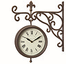 image cut out on white background of brown station clock with intricate arm and round face