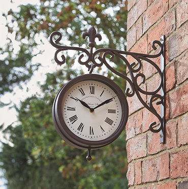 image of station wall clock at dusk on side of shed