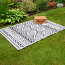 image of slate grey oriental patterned rug on grass with picnic basket