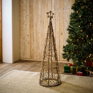 medium sized brown wicker christmas tree with star on top, stood on rug in living room