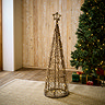 medium sized brown wicker christmas tree with star on top, stood on rug in living room