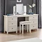 image of off-white dressing table with silver mirror on top and stool pushed slightly underneath