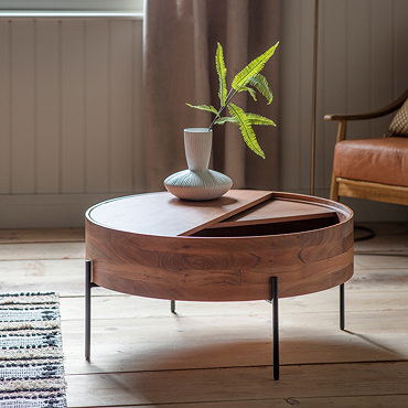 close up on top of round coffee table, with a semicircle panel that moves to conceal storage inside