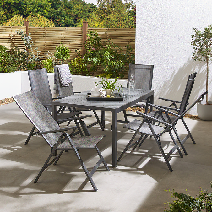 image of outside rectangular dining table surrounded by six high backed grey chairs with backs reclining