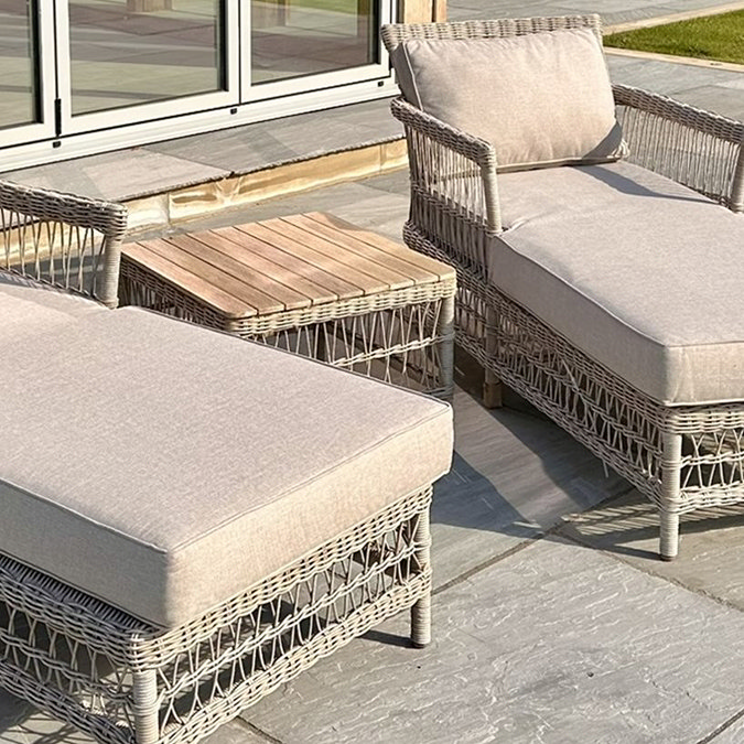 close up image of two beige sun loungers with square coffee table between them