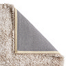 image of beige rug with corner folded over to show material underneath