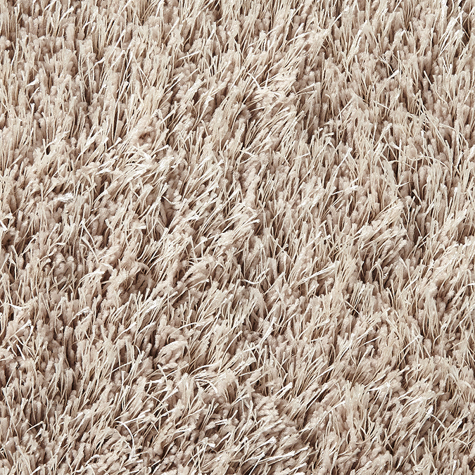 close up on shaggy material of beige rug