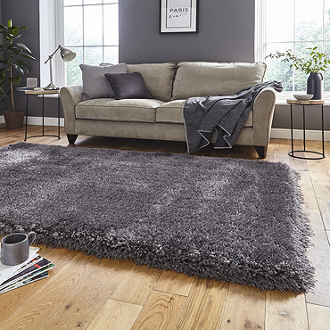 image of dark grey shaggy rug on light wooden floor in modern apartment