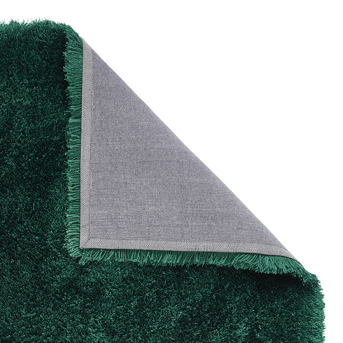 image of emerald green shaggy rug folded over in corner to show floor-facing material underneath