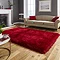 image of large red rug in front of beige sofa with red accent cushions