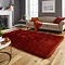 image of terracotta shaggy rug in front of light beige sofa with orange accent cushions