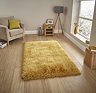 angled image of yellow shaggy rug on light wooden flooring