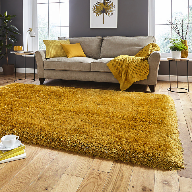 image of mustard yellow shaggy rug in front of beige sofa with yellow accent cushions