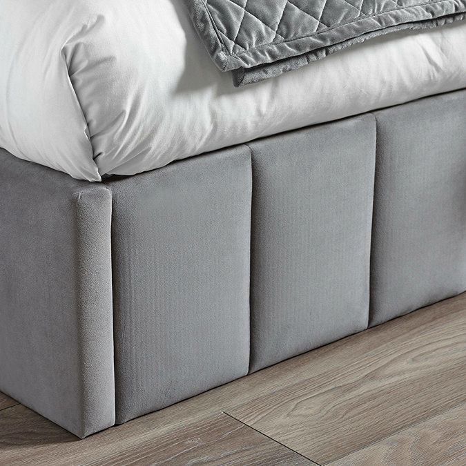close up image on velvet panelled footboard of grey bed