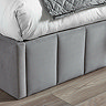 close up image on velvet panelled footboard of grey bed