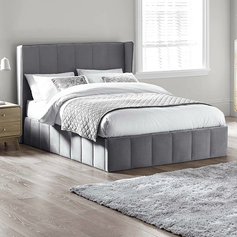 image of grey velvet panelled bed with subtle winged headboard, decorated with mattress and duvet