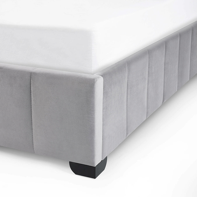 close up image of velvet grey panelled footboard of bed with blocky black metal leg