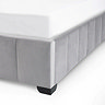 close up image of velvet grey panelled footboard of bed with blocky black metal leg