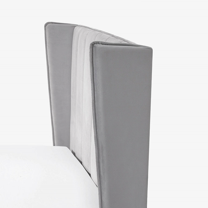 close up image cut out on white background of winged grey headboard of bed
