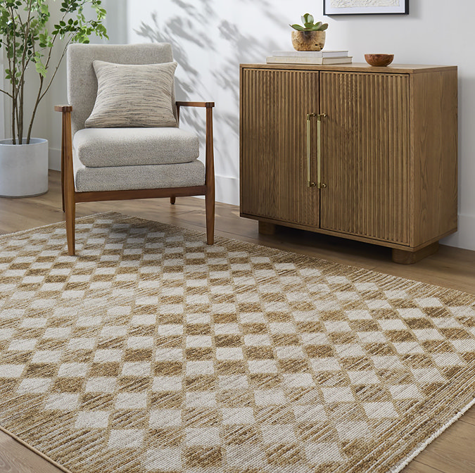 image of mustard and cream diamond pattern rug on light wooden flooring next to fluted sideboard