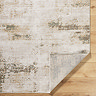 image of rustic area rug in olive green and brown shades folded over at corner to show material underneath