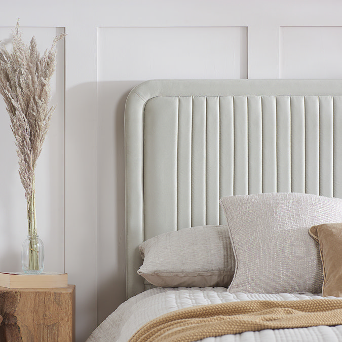 close up on stone channel effect headboard of bed, with light grey cushions leaning against it
