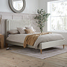 image of bed with wooden feet and vertical channel detailing on the stone coloured headboard, featuring wooden feet