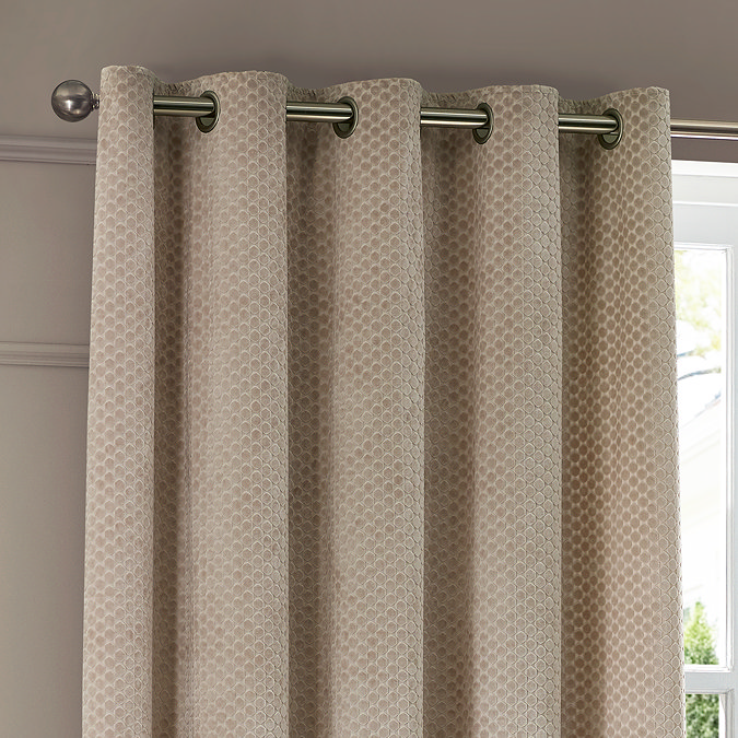 Neptune Eyelet Curtains in champagne over a window close up image