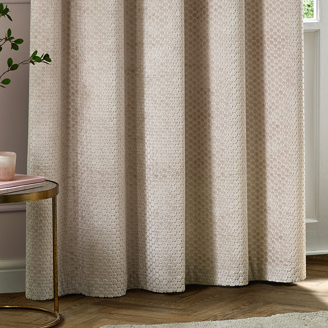 Neptune Eyelet Curtains in champagne over a window close up image