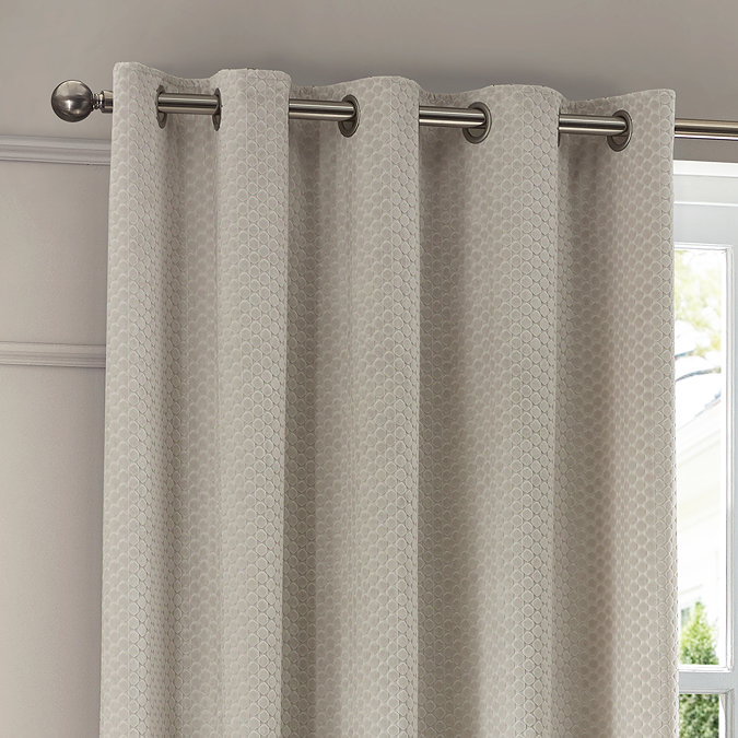 Neptune Eyelet Curtains in Ivory over a window image